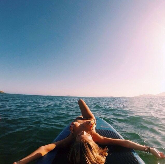 REAR VIEW OF MAN RELAXING ON WATER AGAINST CLEAR SKY