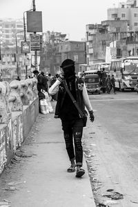 Rear view of man walking on street in city