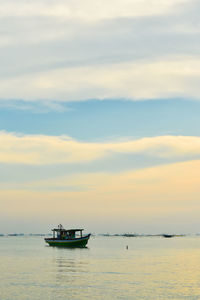 Boats in sea at sunset