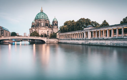 Bridge over spree river by berlin cathedral against sky