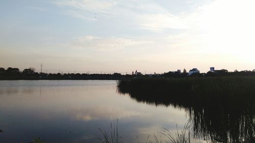 Scenic view of river against sky at sunset