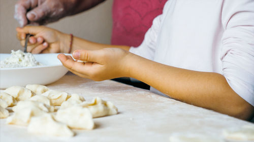 Midsection of woman preparing food at table