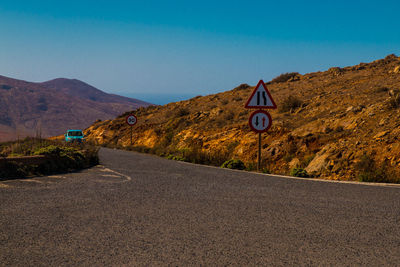 Road sign against clear blue sky