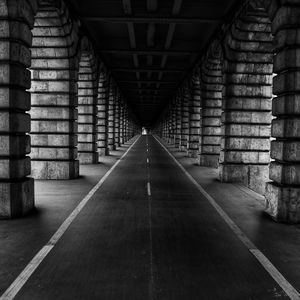 Empty road amidst columns