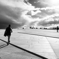 Rear view of woman walking towards people at oslo opera house