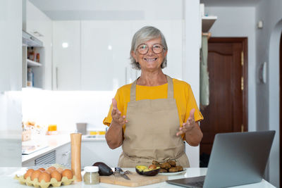 Portrait of young woman using laptop at home