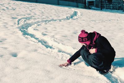 High angle view of man touching snow