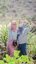 Portrait of women wearing pollution masks standing by rock