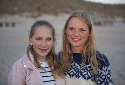 Portrait of smiling sisters standing outdoors