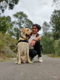 Full length of woman with dog against trees