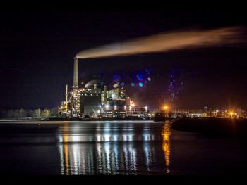 Industrial buildings at riverbank during night