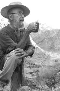 Side view of man standing against mountain