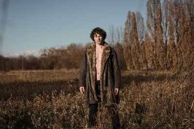 Portrait of young man standing on field