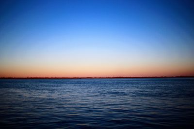 Scenic view of sea against clear sky at sunset