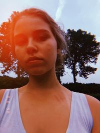 Close-up portrait of young woman against sky