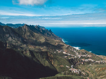 Scenic view of sea and mountains against sky