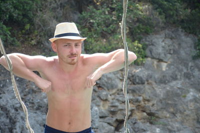 Portrait of shirtless young man wearing rock