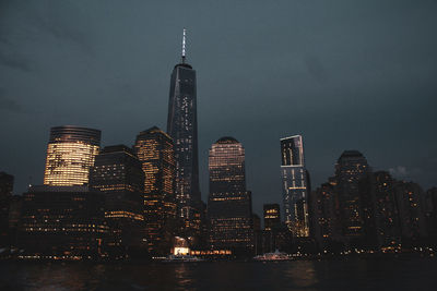 Illuminated buildings in city against sky at night