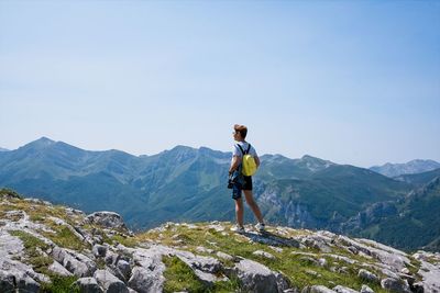 Rear view of woman against mountains against sky