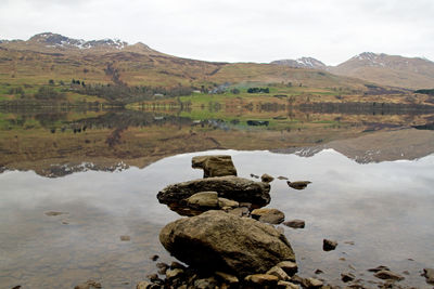 Scenic view of scottish loch against sky