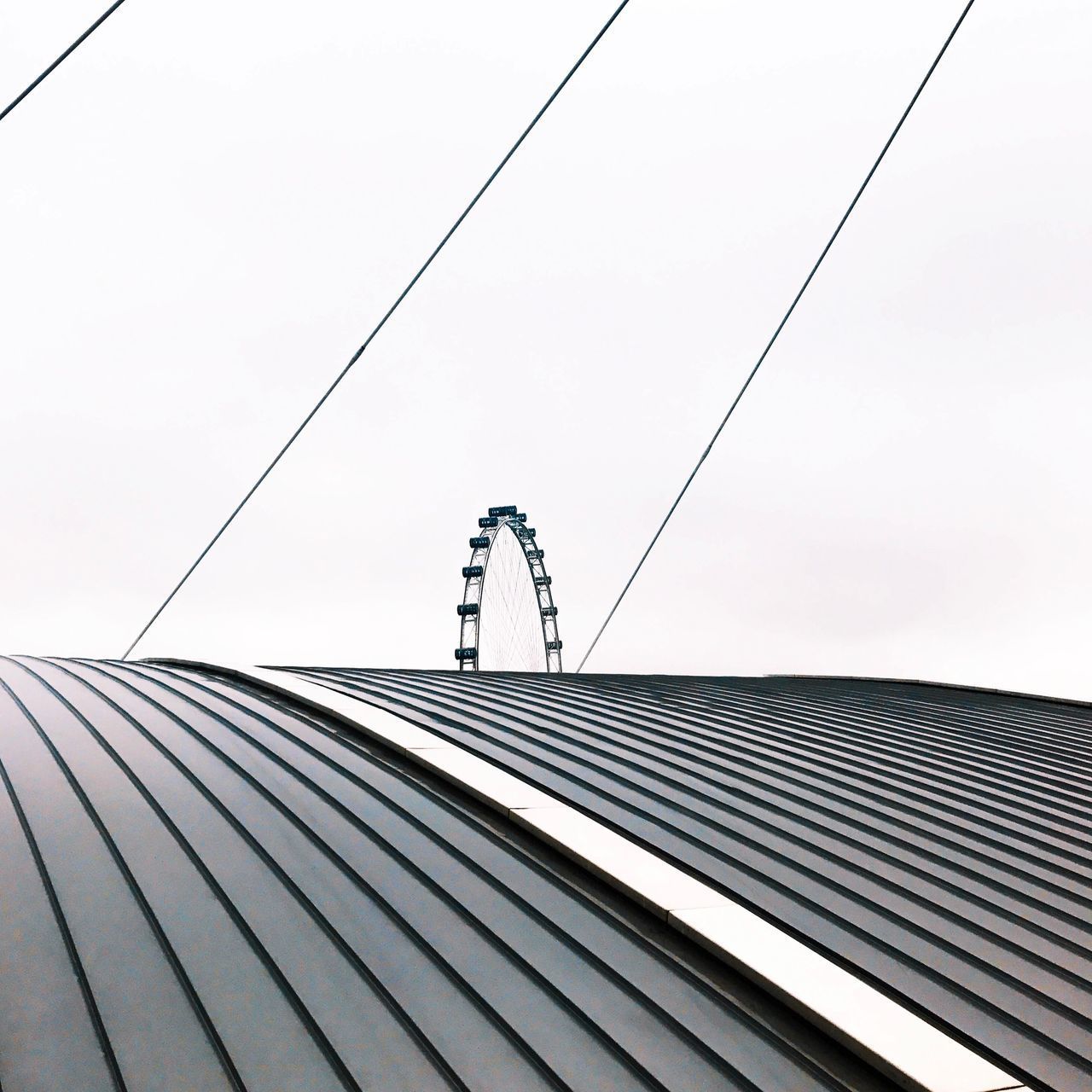 LOW ANGLE VIEW OF PERSON STANDING ON RAILING