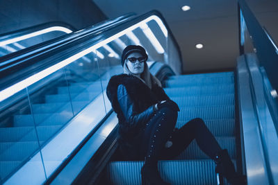 Woman sitting on escalator