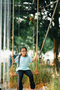 Full length of girl sitting on swing