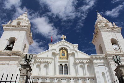 Blanca iglesia con nubes en el cielo azul 