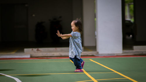 Full length of a girl playing with umbrella