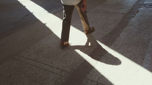 Low section of man walking on zebra crossing