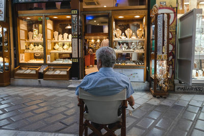 Rear view of man sitting on chair at table