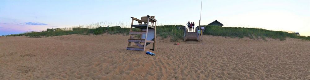 Lifeguard hut on sand against sky