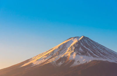 Scenic view of snowcapped mountains against clear blue sky