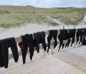 Wetsuits hanging too dry on a fench