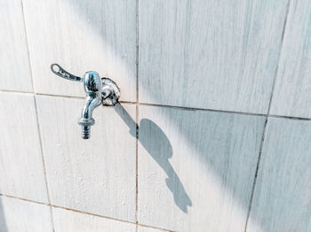 Low angle view of faucet against wall