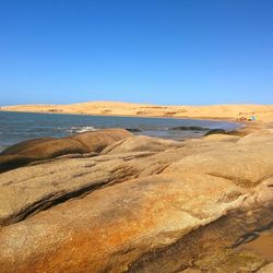 Scenic view of beach against clear blue sky