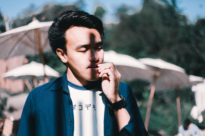 Close-up of man looking down during sunny day