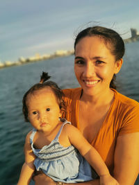 Portrait of happy mother and daughter at shore