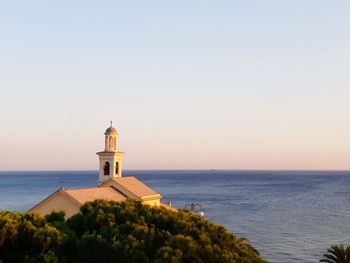 Church by sea against clear sky