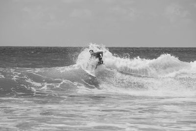 Waves splashing on sea against sky