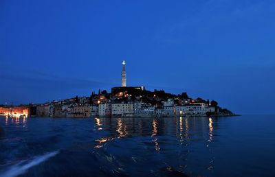 Illuminated buildings in city at waterfront