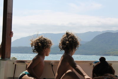 Rear view of two people looking at sea