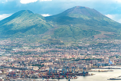 Aerial view of city by sea against sky