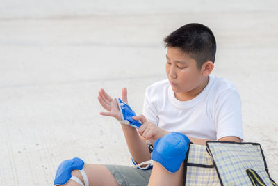 Boy wearing inline skating glove on road