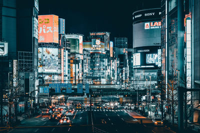 Traffic on city street by buildings at night