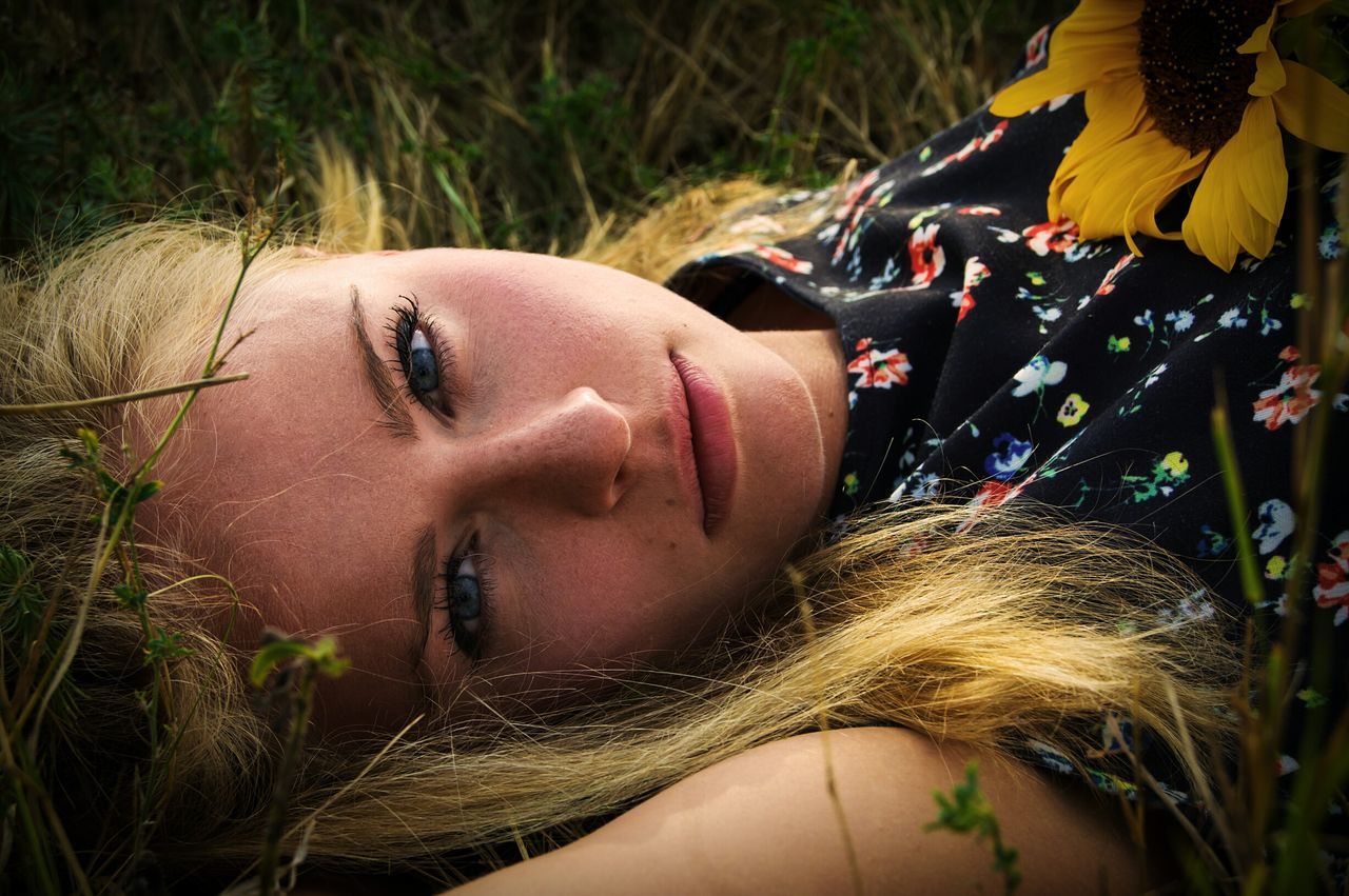 headshot, lifestyles, leisure activity, portrait, close-up, long hair, human face, day, plant, outdoors, focus on foreground, grass, nature, casual clothing, part of