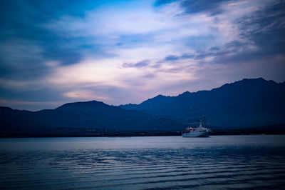 Sailboats in sea against sky during sunset