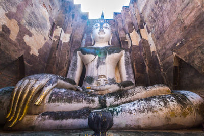Statue of buddha against building