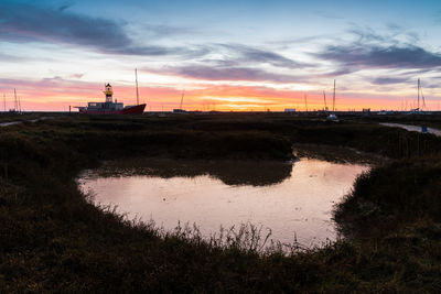 Scenic view of river against sky during sunset