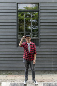 Full length of young man standing against wall